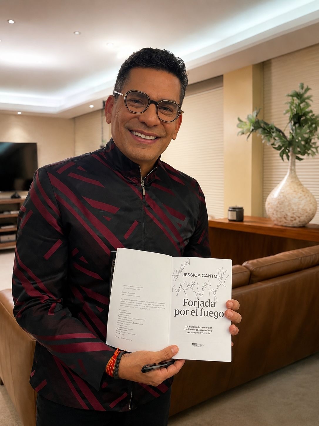 Presentador de televisión con el libro Forjada por el Fuego